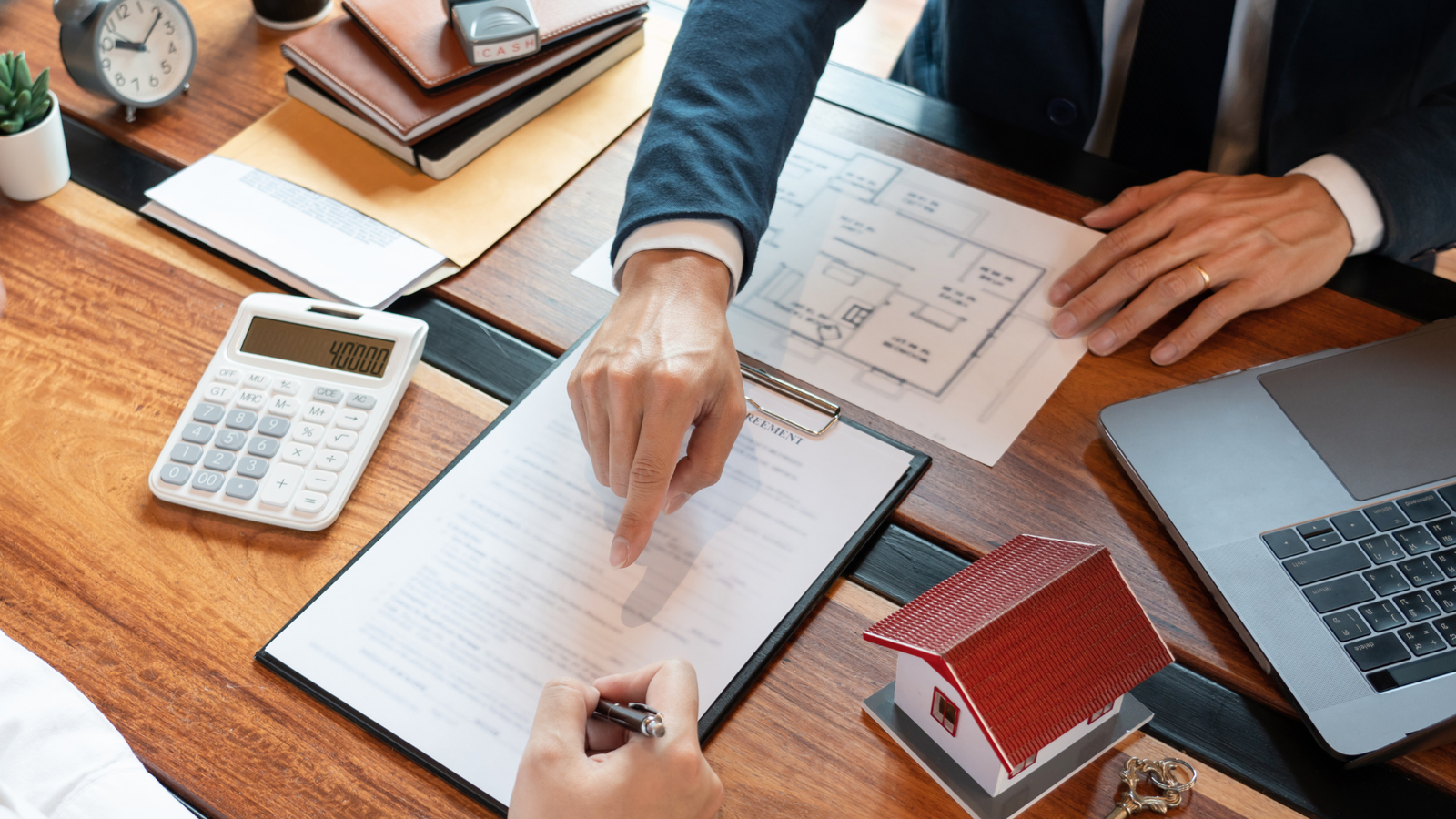 Nekilnojamojo turto dokumentų pasirašymas su skaičiuotuvu.